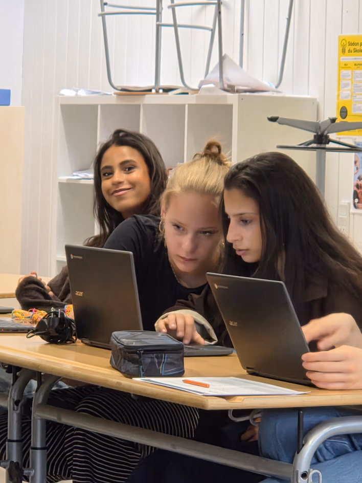 Elever arbejder fokuseret med webdesign i klasselokalet.